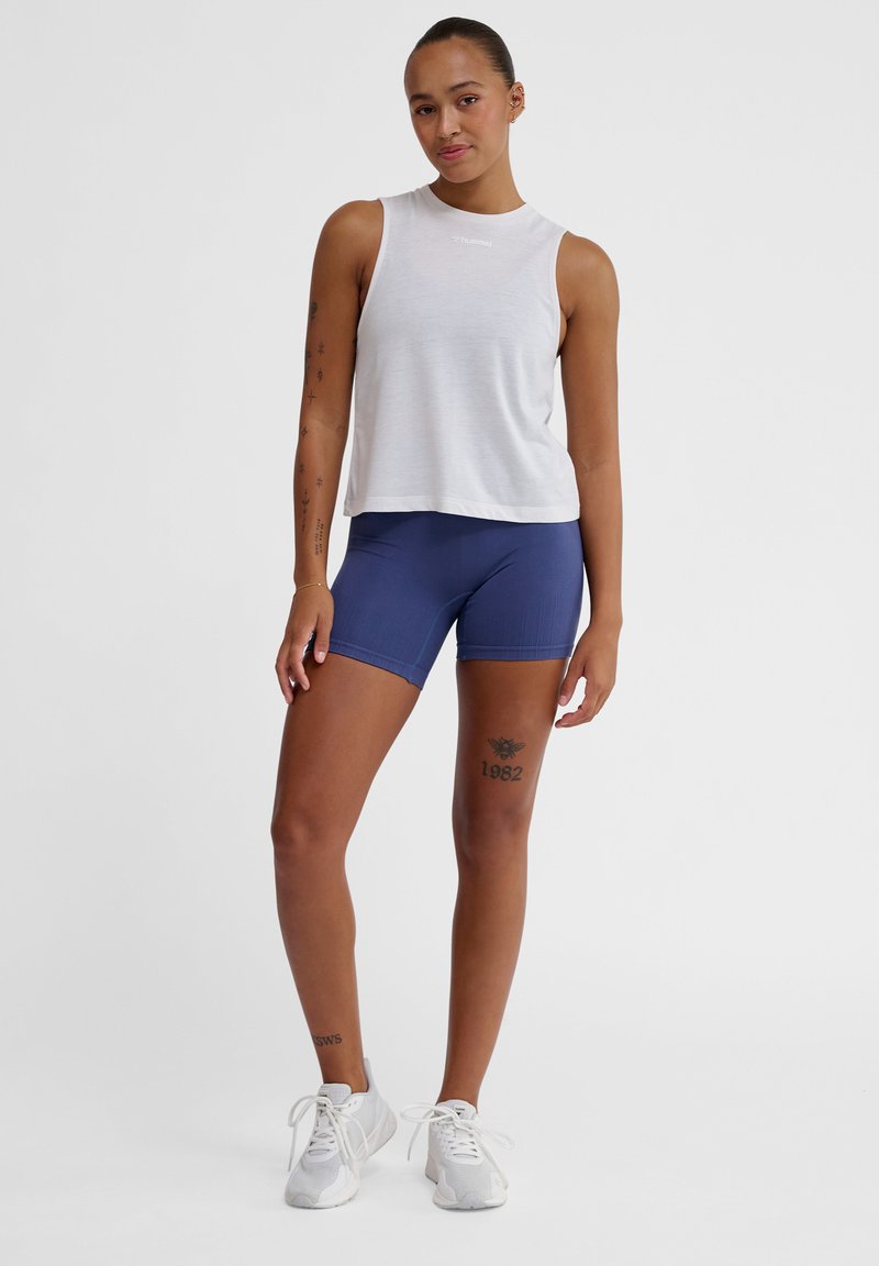 White sleeveless athletic top with a crew neck, paired with navy blue fitted shorts. Both items feature a smooth texture and simple design.