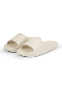 Sandali beige slip-on con una fascia spessa e design aperto sulla punta. Realizzati in materiale plastico liscio, presentano una soletta testurizzata e una suola leggera.