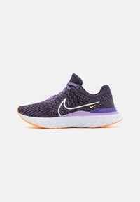 Zapatilla de running morada con parte superior de punto texturizado, logotipo swoosh blanco, acentos naranjas en la suela y una entresuela acolchada para mayor comodidad.