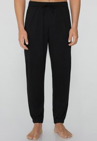 Schwarze Jogginghose aus weichem Stoff, mit elastischem Bund und Kordelzug, mit umgeschlagenen Säumen und lockerer Passform.