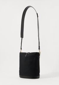 Bolso negro con un cuerpo de tela texturizada y fondo de cuero suave, que cuenta con una larga correa ajustable y detalles en tono dorado.