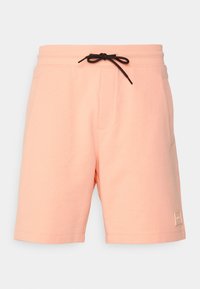 Shorts de sport couleur pêche en mélange de coton avec une taille élastique, un cordon de serrage et des poches latérales. Présente un patch logo.