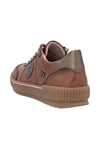 Baskets en cuir marron avec une surface texturée, accent de talon gris contrasté, logo circulaire et détails de couture subtils.