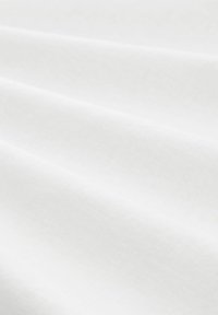 Weißer Stoff mit einer glatten, weichen Textur, der dezente Falten und eine einheitliche Oberfläche aufweist, geeignet für verschiedene Textilanwendungen.