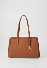 Bolso de cuero marrón con dos asas superiores, forma rectangular, detalle de logo dorado y un colgante con las letras "MK". Textura lisa.