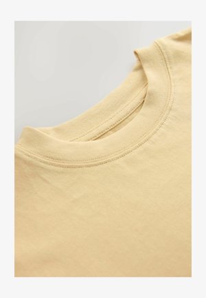 Hellgelbes Baumwoll-T-Shirt mit rundem Ausschnitt, das einen gerippten Kragen und eine glatte Textur aufweist. Der Stoff wirkt weich.
