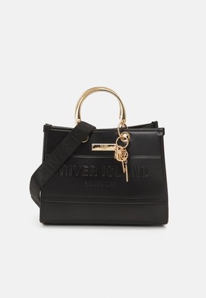 Black River Island handtas met gouden afgerond handvat, decoratieve gouden sleutelhangers en een brede zwarte schouderband op een witte achtergrond.