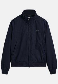 Giacca zip-up blu navy realizzata in tessuto leggero, con colletto alto, polsini elasticizzati e due tasche frontali. Branding discreto sul petto.