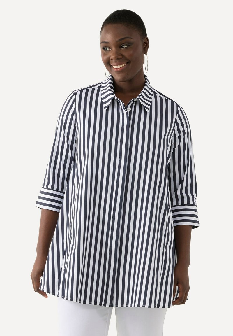 Camicia a righe verticali blu navy e bianca con colletto, maniche a tre quarti e chiusura con bottoni. Il tessuto appare liscio e leggero.