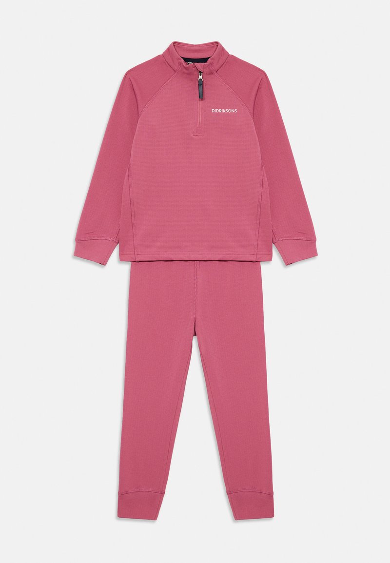 Ensemble deux pièces pour enfants avec un haut à manches longues zippé et un pantalon assorti en rose pâle, comportant le logo de la marque sur la poitrine.