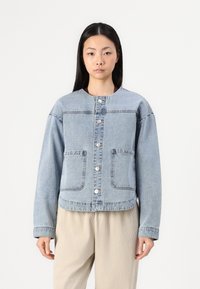 Svijetloplava traper jakna s okruglim izrezom, dva prednja džepa, kopčanje dugmetima i dugim rukavima. Glatka tekstura i opušteni kroj.