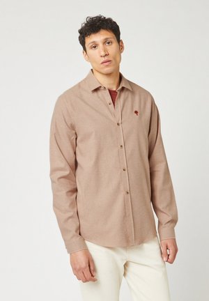 Gestreepte button-up shirt in beige en lichtbruin stof, met een borstzak met een geborduurd ontwerp. Lange mouwen en een ontspannen pasvorm.