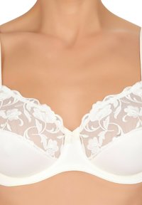 Witte beha met bloemenkant details op de bovenste cups, gladdige stof, gemodelleerde vorm en een strikaccent in het midden.