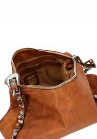 Tan leren handtas met een zilveren rits en decoratief hardwaredetail. Het interieur heeft meerdere vakken en een zachte stofvoering.