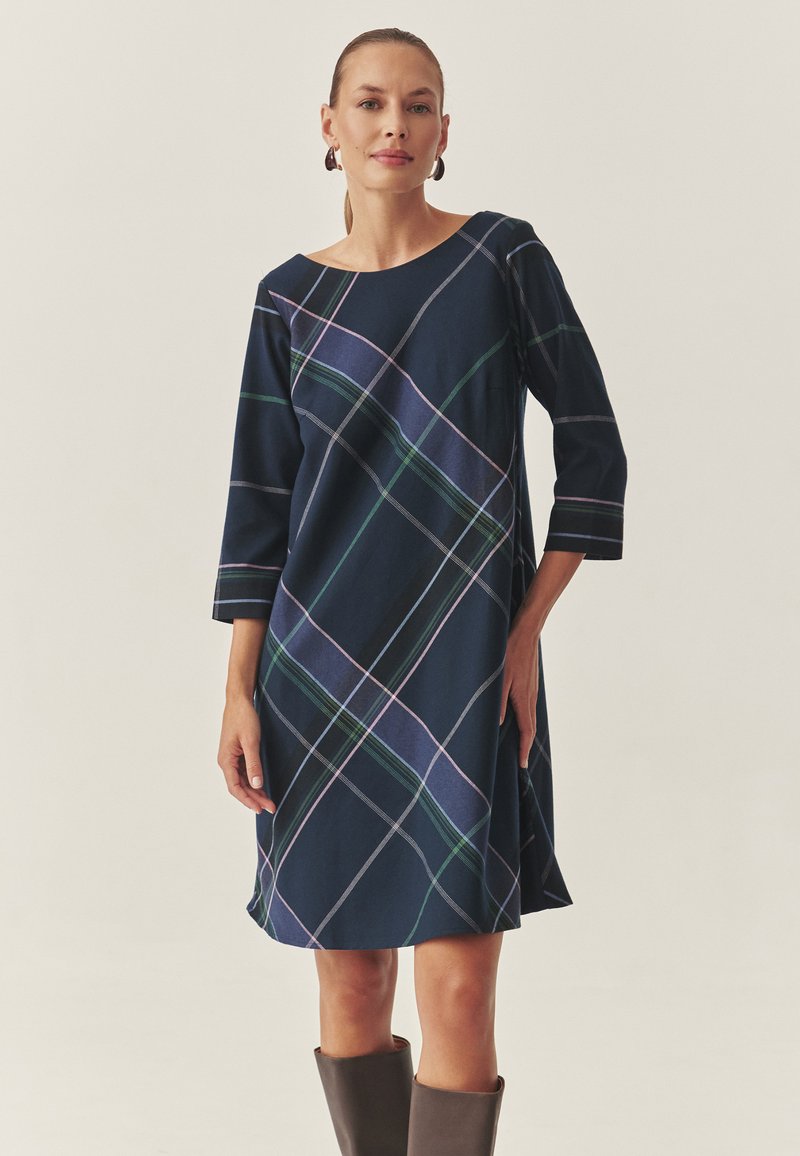 Marineblaues Karokleid mit Dreiviertelärmeln, das ein geometrisches Muster in Grün und Lila aufweist. Hergestellt aus weichem Stoff mit einer lockeren Passform.