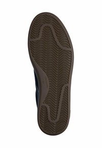 Sole della scarpa realizzata in un materiale gommato marrone texturizzato, caratterizzato da un motivo a onda, progettato per garantire aderenza, con scanalature curve e diritte per flessibilità.