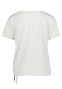 Lös passform vit t-shirt, kort ärm, rund halsringning, sidofickor, mjukt tyg, minimalistisk design, enkel utan mönster eller detaljer.