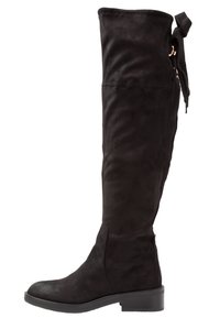 Botte noire en daim montant jusqu'au genou avec un talon bas et un nœud en tissu attaché en haut à l'arrière.