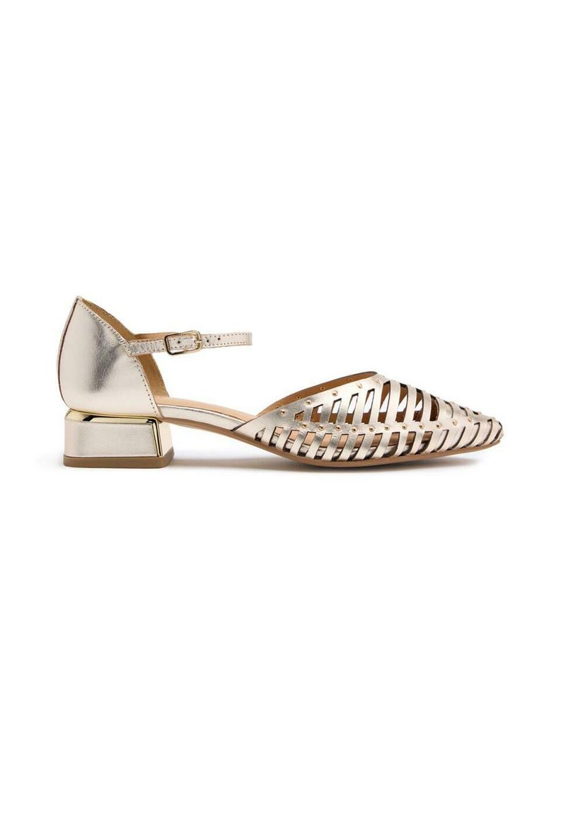 Zapato plano metálico dorado con punta afilada, diseño recortado, tira en el tobillo y un pequeño tacón cuadrado. Presenta un acabado suave y brillante.