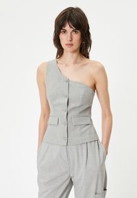 Grijs op maat gemaakte gilet met een schouderontwerp, voorzien van een knoopsluiting en twee voorkruimelzakken. Gladde textuur en subtiel patroon.