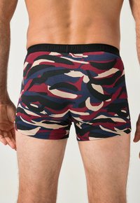 Bokserki w kamuflażowy wzór w kolorach burgundu, granatu, czerni i kremu; wykonane z miękkiego materiału z czarną gumką w pasie.