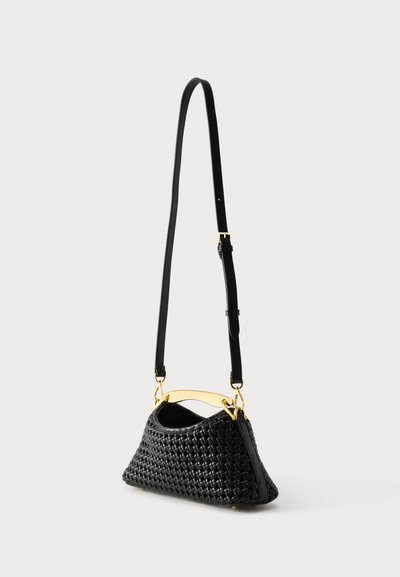 Μαύρη υφαντή δερμάτινη γυναικεία τσάντα με επιμηκυμένο τριγωνικό σχήμα, χρυσή λαβή και ρυθμιζόμενο λεπτό ιμάντα ώμου σε ουδέτερο φόντο.