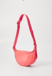 Borsa a tracolla in nylon rosa con forma curva, tracolla regolabile con dettagli del logo impresso e chiusura con zip.