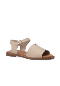 Beige leren sandalen met een open neus en enkelband. Voorzien van een uitgesneden ontwerp en een platte bruine zool. Verstelbare gesp sluiting.