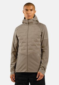 Lightweight beige jacket with textured padded front, hood, full zip closure, and side pockets. Made from a smooth, durable material.