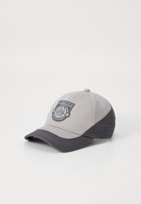 Grå baseball cap med en mørkere grå skygge, med en brodert logo foran. Laget av teksturert stoff, strukturert form.