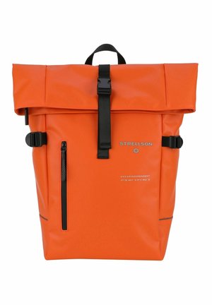 Sac à dos étanche orange avec un rabat enroulable, accessoires noirs, poche latérale zippée et texte imprimé sur le devant. Bretelles réglables pour plus de confort.