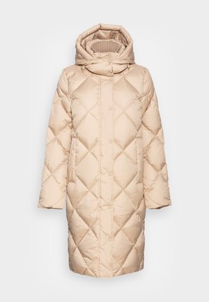 Beżowy, długi, pikowany płaszcz puchowy z wysokim kołnierzem, odpinanym kapturem, zatrzaskami z przodu i bocznymi kieszeniami, zaprojektowany dla ciepła i komfortu.