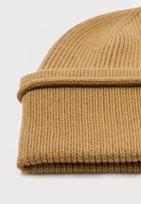 Bonnet en tricot marron en fil texturé, avec un revers replié et un motif en côtes verticales. Convient pour une utilisation par temps froid.