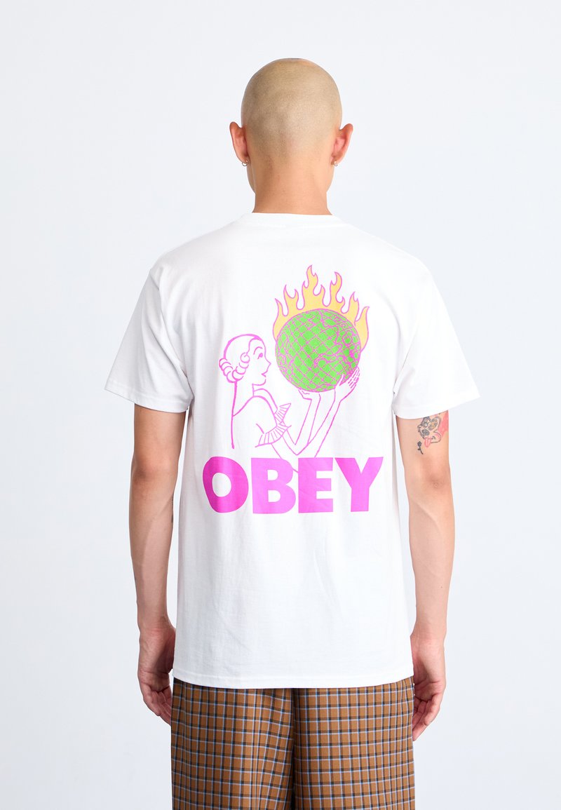 White cotton T-shirt featuring a graphic design on the back. The design includes a pink "OBEY" text, flames, and a green globe held by a figure.
