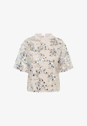 Top de manga corta en crema con cuello redondo, adornado con lentejuelas plateadas y azules en un patrón floral, con cierre de lazo en la parte posterior.