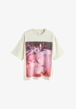 Tricou crem cu mâneci scurte, prezentând un imprimeu floral mare și colorat pe partea din față. Material moale, cu croială lejeră și decolteu rotund.