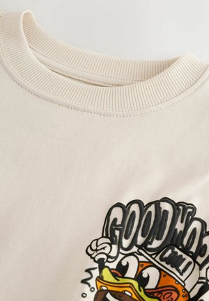 Bluză din bumbac de culoare crem, prevăzută cu guler reiat și un imprimeu grafic cu o rață stilizată și text îndrăzneț "GOOD" și "WOW".