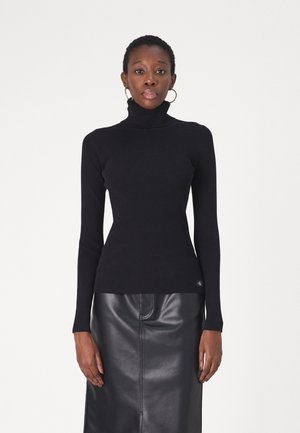 Maglione nero a collo alto a costine realizzato in tessuto morbido, design aderente, maniche lunghe, abbinato a una gonna in pelle nera con una superficie liscia.