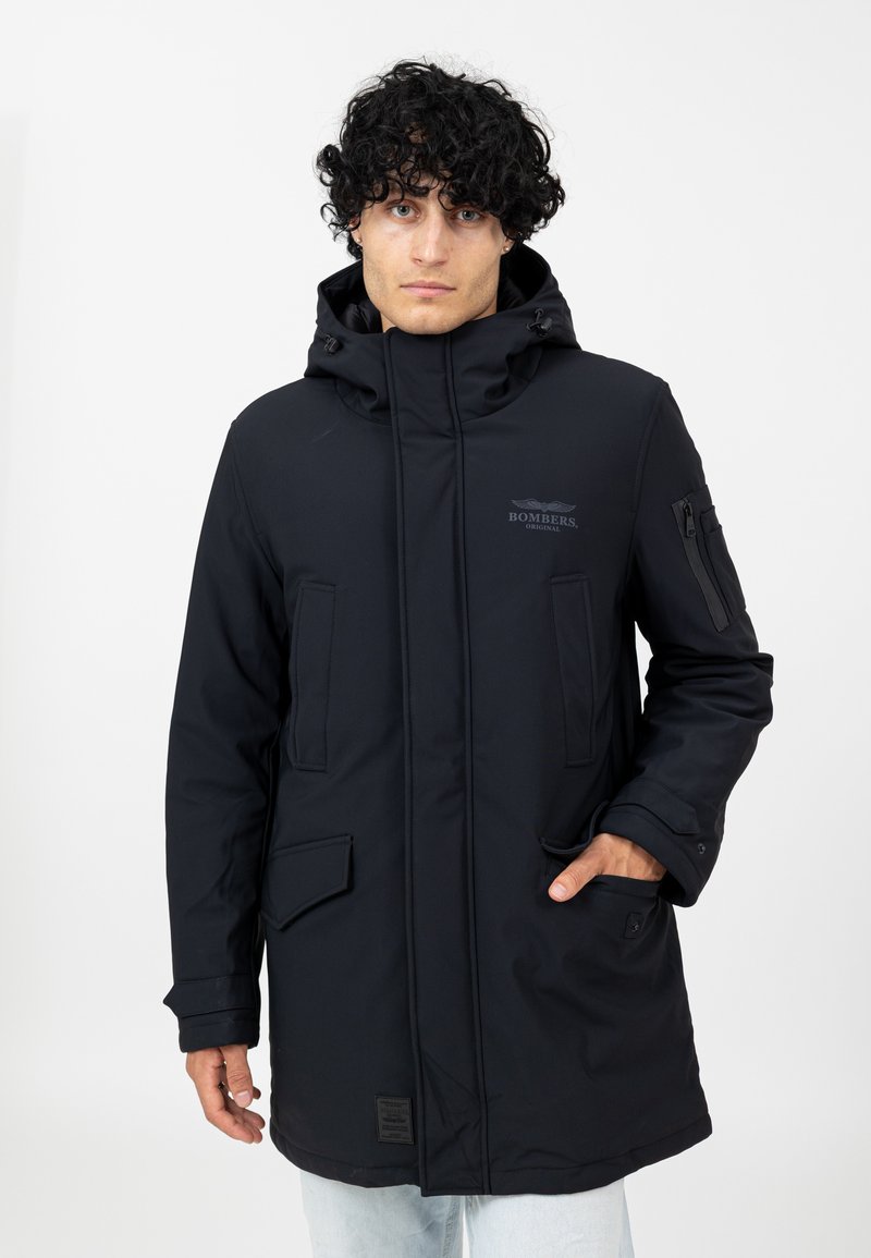 Schwarze Kapuzenparka-Jacke mit hohem Kragen, mit Reißverschluss und Knöpfen versehenen Taschen sowie einem Logo-Print. Glattes, wasserabweisendes Material; figurnahe Silhouette.