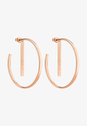 Roze gouden creolen hebben een strakke, open ontwerp met een verticale staafaccent gegraveerd met "LIEBESKIND." Zachte metalen textuur en lichtgewicht.