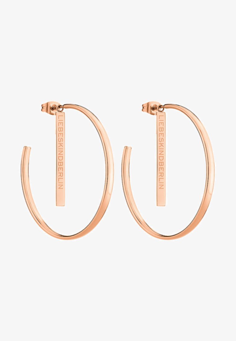 Roze gouden creolen hebben een strakke, open ontwerp met een verticale staafaccent gegraveerd met "LIEBESKIND." Zachte metalen textuur en lichtgewicht.