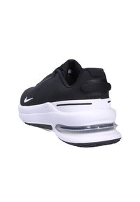 Scarpa sportiva nera con tomaia in tessuto, intersuola bianca e cuscinetto d'aria trasparente. Presenta dettagli con logo e una suola testurizzata per una buona aderenza.