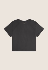 Camiseta negra de manga corta con cuello redondo, que presenta una textura suave y una pequeña etiqueta de la marca cerca de la parte posterior del cuello.