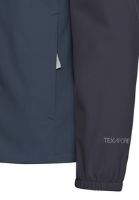 Tissu de veste TEXAPORE bleu marine avec une texture lisse, doté de poignets élastiques et d'une poche latérale doublée de mesh blanc.