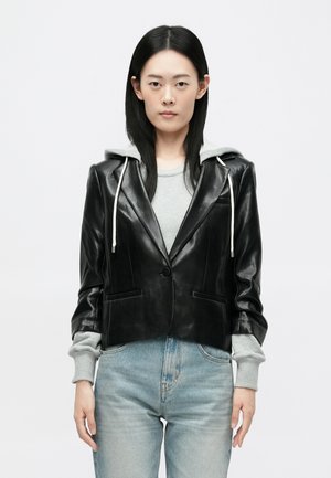 Juodas odinis trumpas švarkas su pilku sportiniu kapišonu; pasižymi lygiu paviršiumi, pritaikytu siluetu ir dviem priekinių kišenių. Kasdienis dizainas.