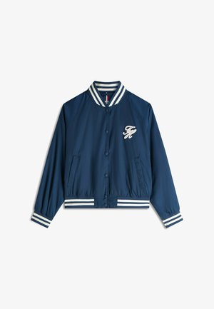 Marineblå bomberjakke med hvidstribet krave, ærmekanter og kant, trykknapper, forlommer og hvidt broderet "FM" logo på venstre bryst.