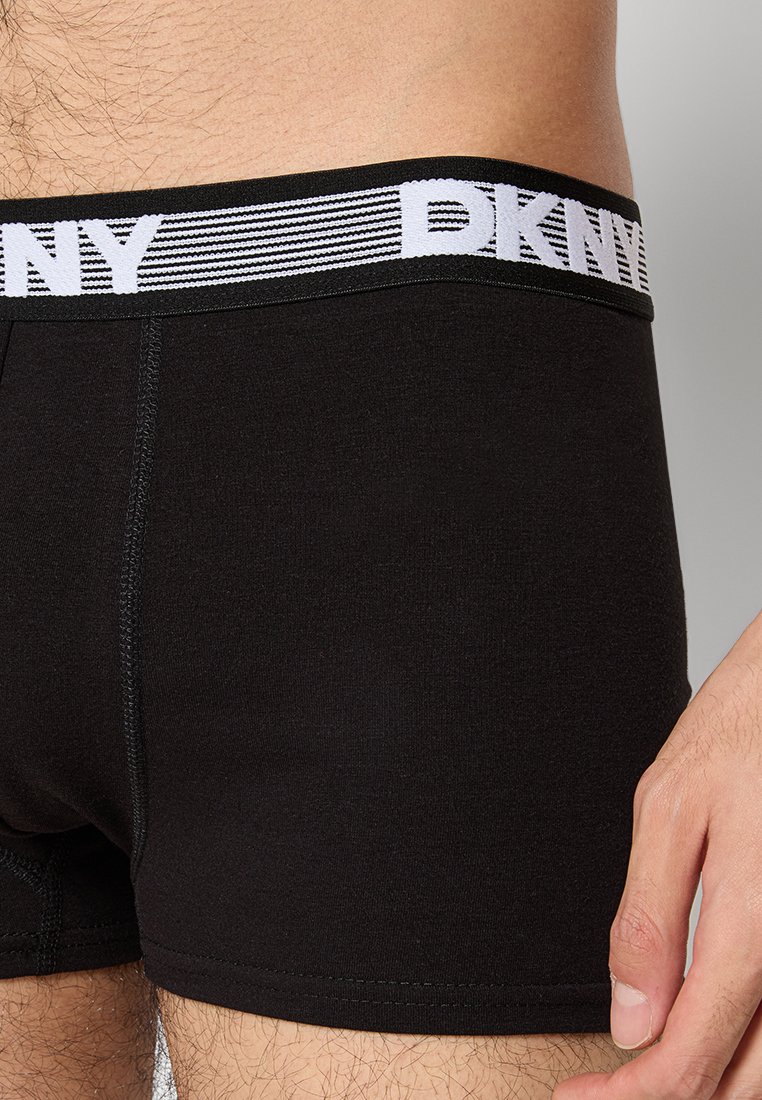 Czarne bawełniane bokserki DKNY z szerokim elastycznym pasem w talii, z białym logo i paskowanymi akcentami; dopasowane, z płaskimi szwami.