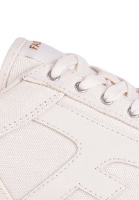 Weiße Leinenschuhe mit einer strukturierten Stoffoberfläche, Akzenten aus synthetischem Leder, Metallösen und flachen Baumwollschnürsenkeln.