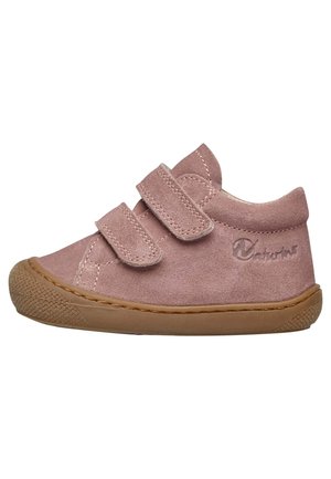 Des chaussures pour tout-petits en suède rose avec deux sangles Velcro, un bout arrondi et une semelle en caoutchouc texturé pour une meilleure adhérence. Le logo est embossé sur le côté.
