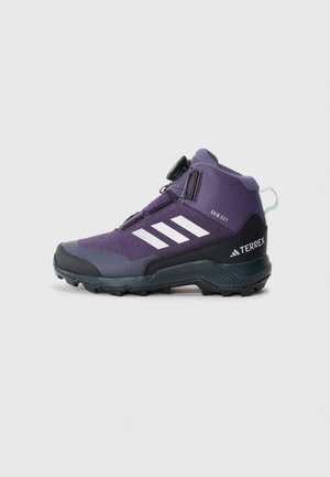 Chaussure de randonnée mi-haute violette avec une tige texturée, des accents noirs, trois rayures blanches, un système de laçage BOA et une semelle extérieure robuste.